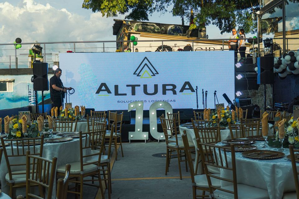 Pantalla LED gigante con la marca Altura en un evento corporativo de aniversario, con montaje de sonido e iluminación